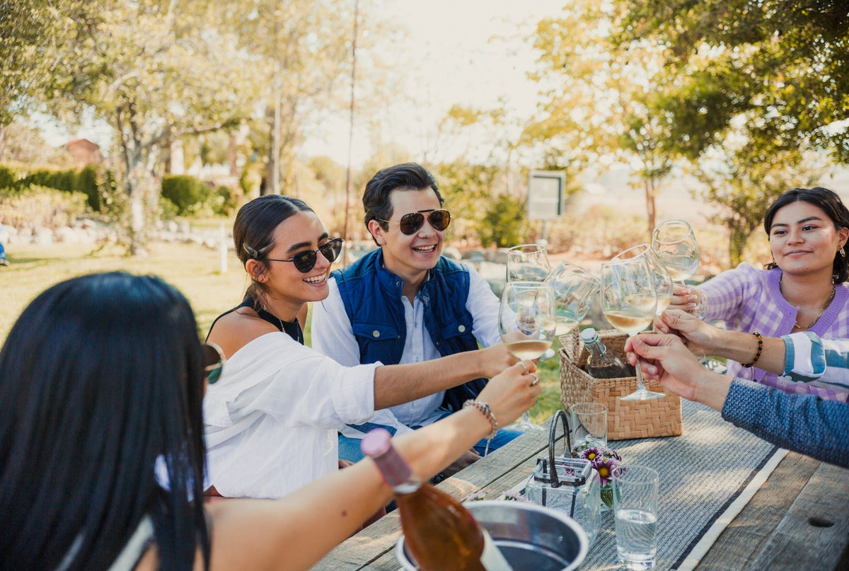 Grupo de visitantes brindando alrededor de una mesa en los jardines de Rondo del Valle.